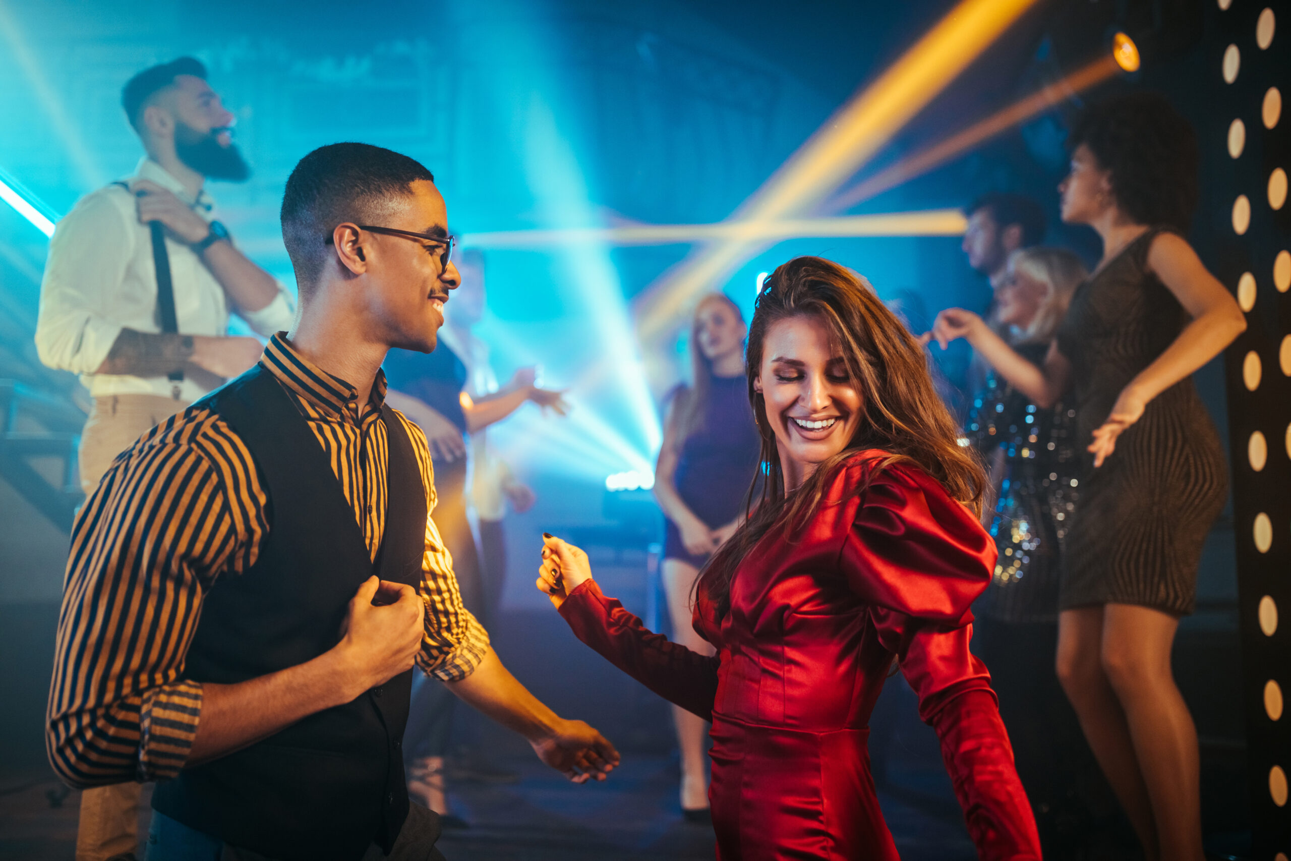 An affectionate young couple dancing together in a nightclub