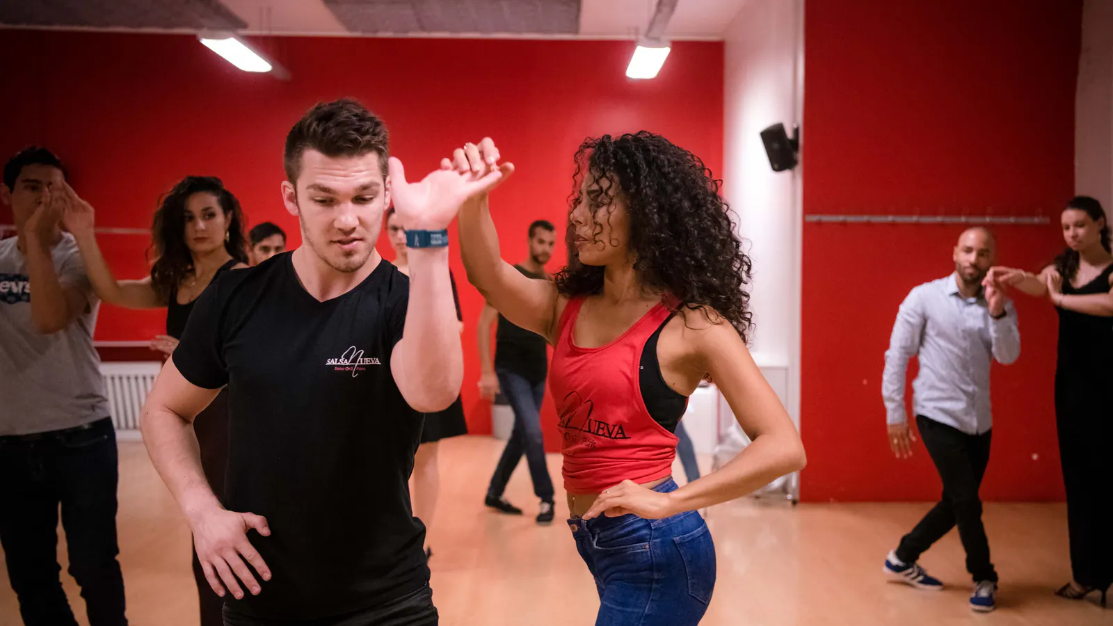 Élèves adultes en initiation salsa travaillant les pas de base avec un professeur
